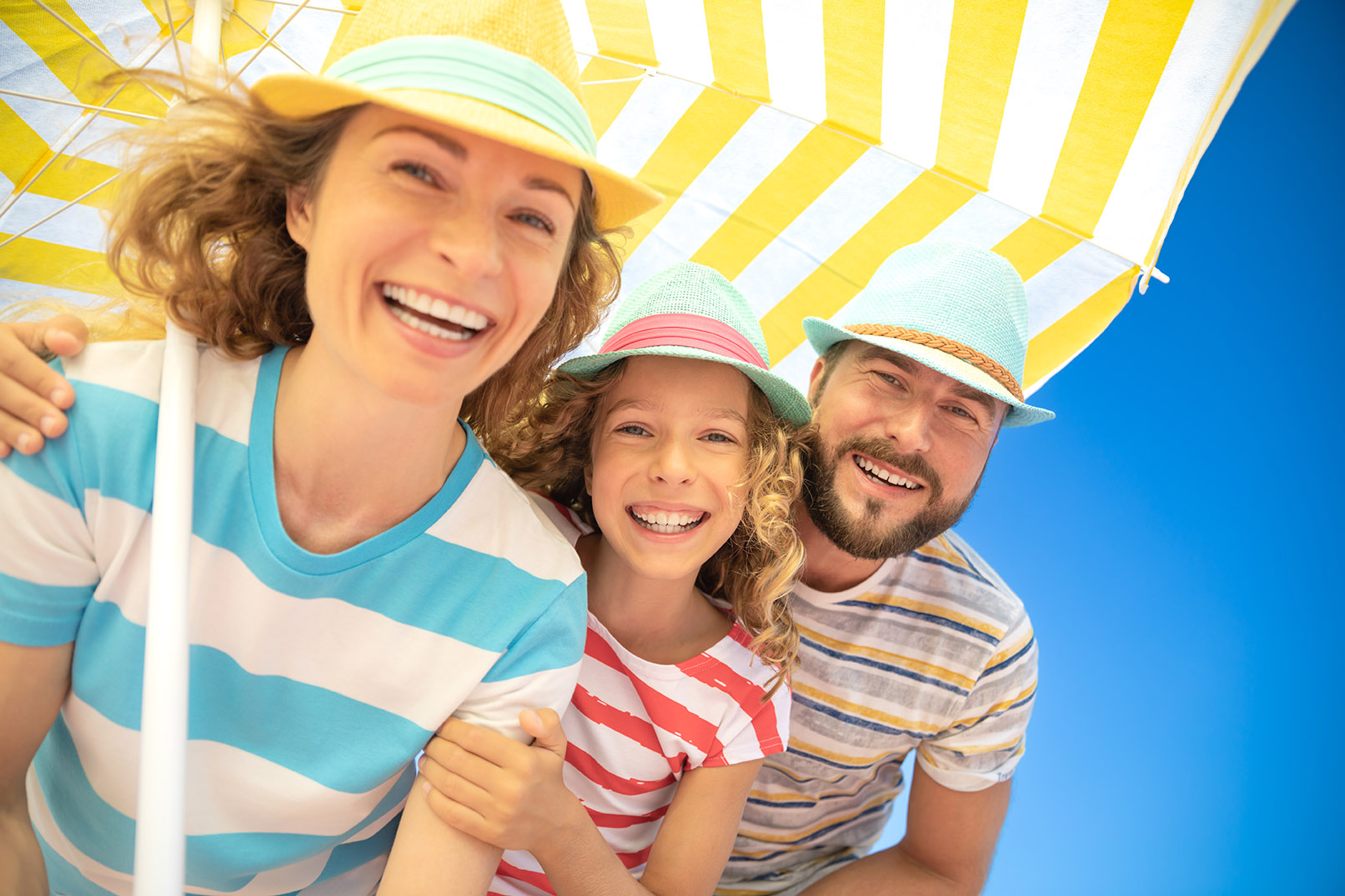 Happy family on summer vacation. Low angle view portrait of happy people against blue sky background